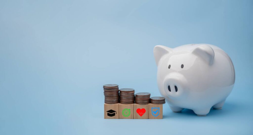 Mealheiro branco com pilhas de moedas simbolizando poupança e investimento em formação profissional através do Fundo de Compensação do Trabalho.